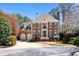 Stately brick home with mature landscaping and a two-car garage on a sunny day at 4620 Chattahoochee Se Xing, Marietta, GA 30067