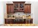 Close up of a kitchen featuring a stainless farmhouse sink, dishwasher, and custom dark wood cabinetry at 4620 Chattahoochee Se Xing, Marietta, GA 30067