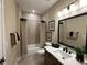 Bathroom with a white vanity top, dark accents, a framed mirror, and a tiled bathtub with a neutral curtain at 1601 Bonica Xing # 1601, Cumming, GA 30040