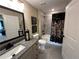 Bathroom featuring a granite vanity top, a large framed mirror, and a tiled shower with floral shower curtain at 1601 Bonica Xing # 1601, Cumming, GA 30040