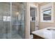 Updated bathroom featuring tiled shower with glass door, window and vanity with marble countertop at 2724 Janellen Dr, Atlanta, GA 30345