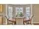 Sunlit breakfast nook features a round table, comfortable chairs, and large windows with backyard views at 4145 Alveston Dr, Atlanta, GA 30349