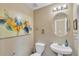 Cozy powder room features artwork, an oval mirror, and a pedestal sink at 4145 Alveston Dr, Atlanta, GA 30349