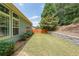 Landscaped backyard with retaining wall, and green lawn at 515 Roland Manor Dr, Dacula, GA 30019