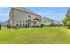 Wide angle view of a manicured backyard with green grass, black fencing, and a covered patio at 6210 Bellmoore Park Ln, Duluth, GA 30097