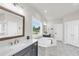 Bright bathroom featuring a marble tub, separate shower, and double vanity sinks at 6210 Bellmoore Park Ln, Duluth, GA 30097