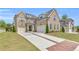 Beautiful brick home featuring a three-car garage, brick-lined driveway and manicured landscaping at 6210 Bellmoore Park Ln, Duluth, GA 30097