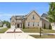 A stately brick home featuring a manicured lawn, three car garage, and brick-lined driveway at 6210 Bellmoore Park Ln, Duluth, GA 30097
