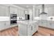 A modern gourmet kitchen features light gray cabinets, a marble-top island, and stainless steel appliances at 6210 Bellmoore Park Ln, Duluth, GA 30097