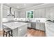 Bright kitchen features an island with quartz countertop, stainless steel appliances, and hardwood floors at 6210 Bellmoore Park Ln, Duluth, GA 30097