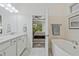 This bathroom has a double vanity, a soaking tub, and a view into the primary bedroom at 1098 Central Park Rd, Decatur, GA 30033