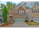 Two-story home featuring a brick and stone exterior, two car garage, and well maintained landscaping at 1098 Central Park Rd, Decatur, GA 30033