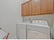 Well-lit laundry room featuring white front load washer and dryer along with wooden cabinets at 1098 Central Park Rd, Decatur, GA 30033