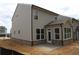 Rear view of the house featuring neutral colored siding, brick foundation, and a covered patio at 1974 William Glen St, Dacula, GA 30019
