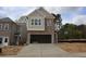 New construction home featuring a brick and siding facade with an attached two-car garage at 1974 William Glen St, Dacula, GA 30019