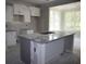 Unfinished kitchen featuring white cabinets, an island, and an adjacent sunroom at 1974 William Glen St, Dacula, GA 30019