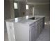 Close up view of the kitchen island featuring gray cabinets and a stainless steel sink at 1974 William Glen St, Dacula, GA 30019