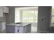 Unfinished kitchen featuring white cabinets, an island, and an adjacent sunroom at 1974 William Glen St, Dacula, GA 30019