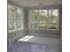 A sunroom with light-colored walls and white trim and windows overlooking the backyard at 1974 William Glen St, Dacula, GA 30019