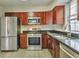 Well-lit kitchen with stainless steel appliances, granite countertops, and wood cabinets at 2463 Corner Shoals Dr, Decatur, GA 30034