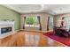 Cozy living room area with fireplace, hardwood floors, and windows looking out to the back yard at 79 Tiffany Trce, Palmetto, GA 30268
