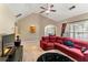 Comfortable living room featuring large windows, a red sofa, and open access to kitchen and dining areas at 79 Tiffany Trce, Palmetto, GA 30268
