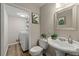 A bathroom with a pedestal sink, toilet, and a laundry area with a washing machine at 1720 Little Willeo Rd, Marietta, GA 30068