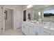 Bright bathroom with double sink vanity, framed mirror, shower, and a view at 3048 Shirecrest Ln, Dacula, GA 30019