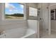 Soaking tub and glass shower featured in bright bathroom with a large window at 3048 Shirecrest Ln, Dacula, GA 30019