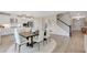 Open dining area near a modern kitchen with a large island and stainless steel appliances, next to staircase at 3048 Shirecrest Ln, Dacula, GA 30019