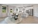 Dining area with modern table and chairs, opening to a bright kitchen with stainless steel appliances and island seating at 3048 Shirecrest Ln, Dacula, GA 30019