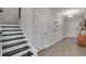 Inviting entryway with dark stairs and a view of the art hung on the wall at 3048 Shirecrest Ln, Dacula, GA 30019