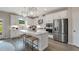 Modern kitchen featuring white cabinets, stainless steel appliances, a kitchen island, and stylish pendant lighting at 3048 Shirecrest Ln, Dacula, GA 30019