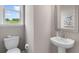 Simple powder room with pedestal sink, toilet, and framed mirror, offering functionality and minimalist design at 3048 Shirecrest Ln, Dacula, GA 30019