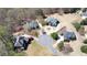 The aerial view displays mature trees and lush landscaping in a neighborhood with homes with circular driveways at 3230 Munsey Ct, Cumming, GA 30041
