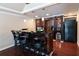 This bar area features a dark wood bar with seating, a sink, ice maker, storage and modern pendant lighting at 3230 Munsey Ct, Cumming, GA 30041
