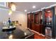 This bar area features a dark wood bar with seating, a sink, ice maker, storage and modern pendant lighting at 3230 Munsey Ct, Cumming, GA 30041
