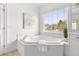 Bright bathroom featuring a jacuzzi style tub, a large window, and tile floors at 3230 Munsey Ct, Cumming, GA 30041