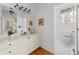 Bright bathroom with marble countertop vanity, decorative mirror, and open doorway to a toilet room at 3230 Munsey Ct, Cumming, GA 30041