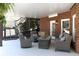 This covered patio features brick construction, outdoor seating, and a serene view of the landscaped backyard at 3230 Munsey Ct, Cumming, GA 30041