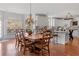 Dining area with hardwood floors, wooden table and chairs, adjacent to kitchen with island and modern cabinets at 3230 Munsey Ct, Cumming, GA 30041