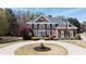 Stately brick home with manicured lawn, circular drive, and mature trees at 3230 Munsey Ct, Cumming, GA 30041