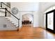 Bright foyer with hardwood floors, staircase, and view into dining room at 3230 Munsey Ct, Cumming, GA 30041