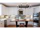 Bright kitchen featuring white cabinets, mosaic tile backsplash, stainless steel appliances, and a wooden kitchen island at 3230 Munsey Ct, Cumming, GA 30041