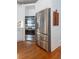 Close-up of stainless steel refrigerator and oven appliances with built-in cabinetry and hardwood flooring at 3230 Munsey Ct, Cumming, GA 30041