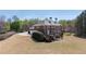 The two-story red brick home features a spacious deck, walkout basement, and beautiful yard with mature trees at 3230 Munsey Ct, Cumming, GA 30041