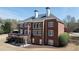 Two-story red brick home featuring a spacious deck with a landscaped yard, a walkout basement and multiple windows at 3230 Munsey Ct, Cumming, GA 30041