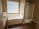 Bright bathroom featuring a soaking tub under a window and separate glass-enclosed shower at 3615 Hutchinson Trace Dr, Cumming, GA 30040
