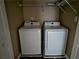 Convenient laundry room with modern, white washer and dryer units and wire shelving at 3615 Hutchinson Trace Dr, Cumming, GA 30040