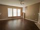 Spacious living room featuring hardwood floors, ample natural light, and a ceiling fan at 3615 Hutchinson Trace Dr, Cumming, GA 30040